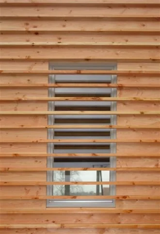 Holzfassade mit horizontalen Lamellen und Sichtfenster